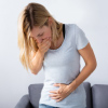 Pregnant female feeling nauseous with her hand on her mouth, showing the concept of molar pregnancy