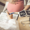 Doctor writing prescription for a pregnant female