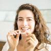 Female holding invisible teeth aligners