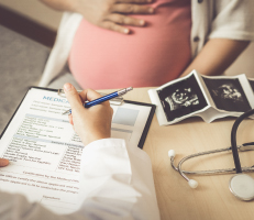 Doctor writing prescription for a pregnant female